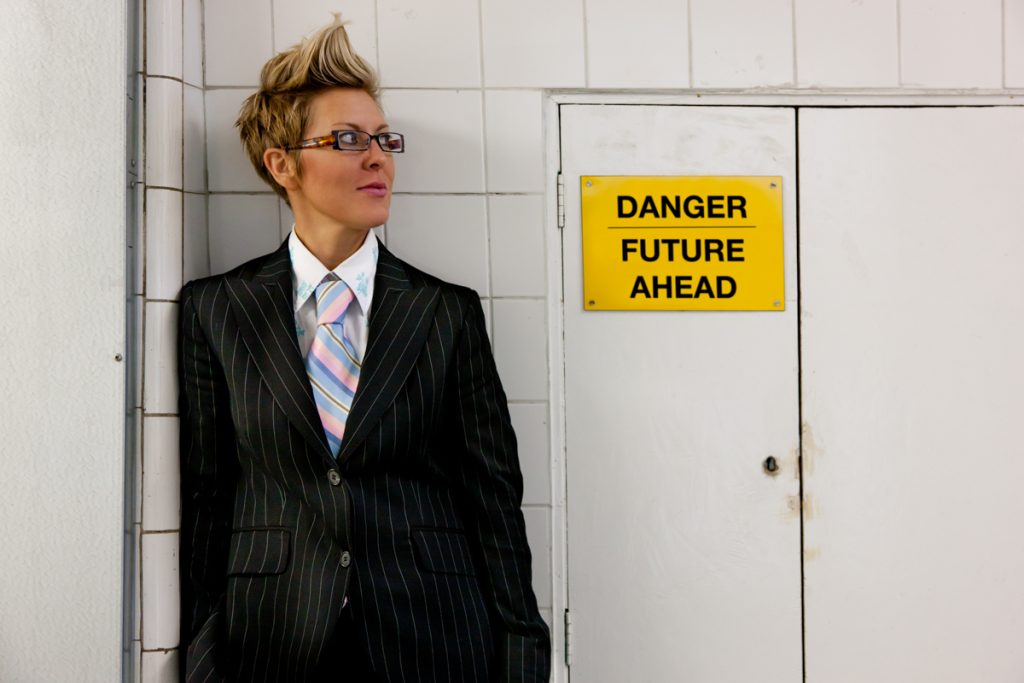 Food futurologist Dr Morgaine Gaye leans against a white wall wearing a black suit blazer