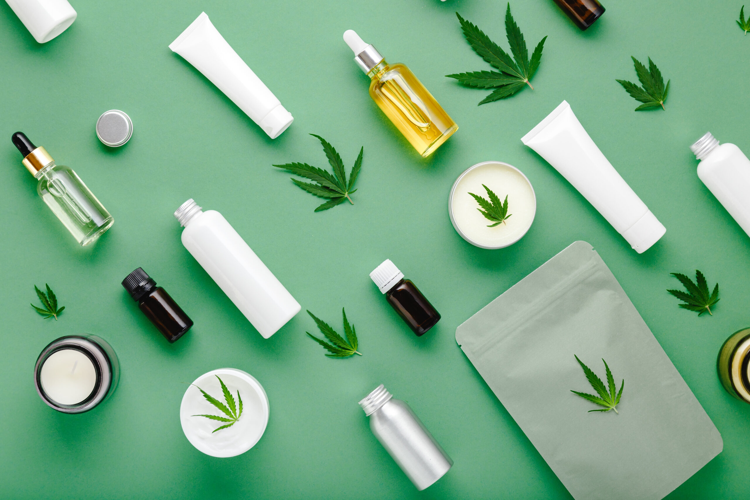 Hemp and CBD products pictured laying flat on a green background